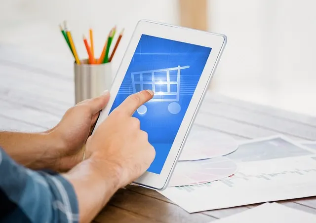 Man completing digital shopping cart checkout process on tablet