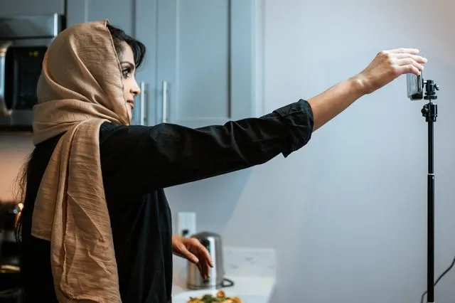 Woman adjusting camera to record an explainer video